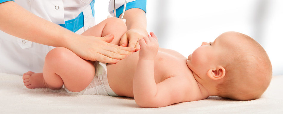 A Doctor examines and massaging baby tummy