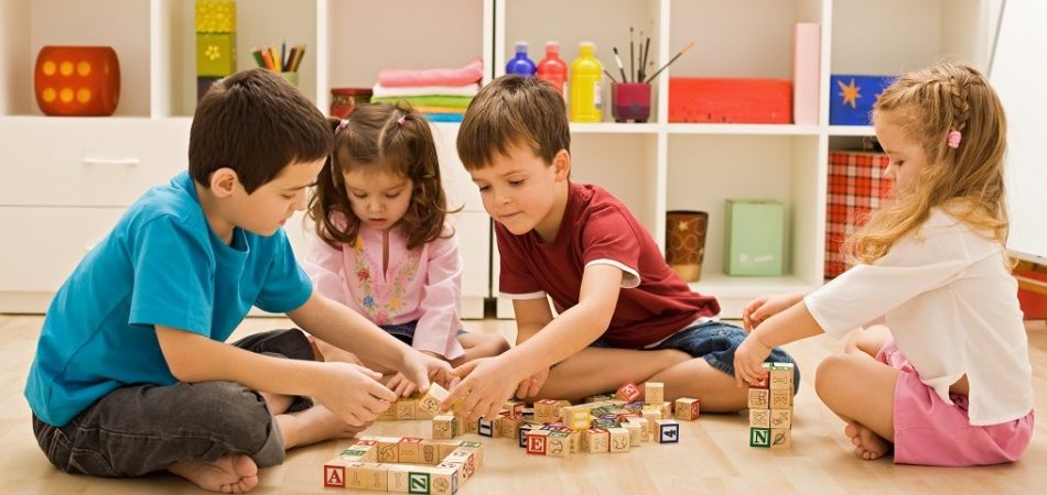 Children playing with blocks on the floor - focus on the boy's face