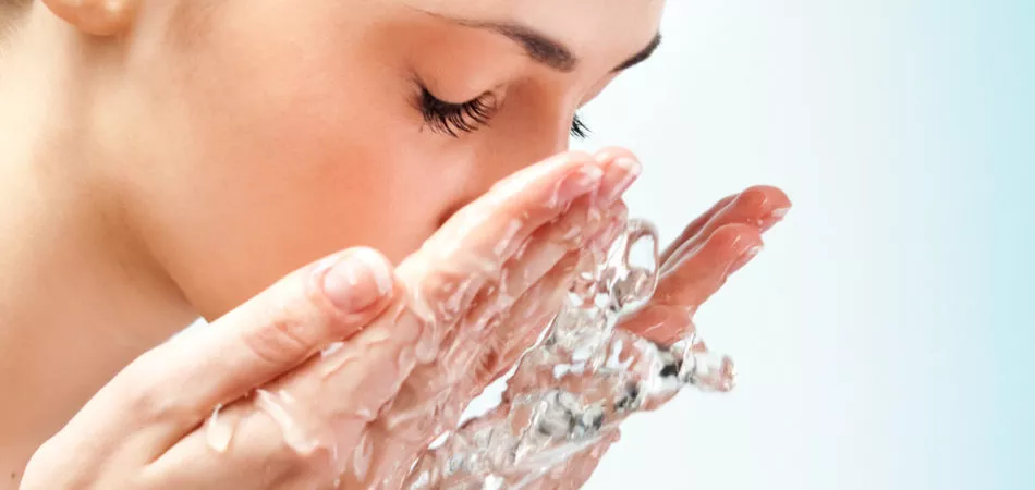 Healthy woman washing her face