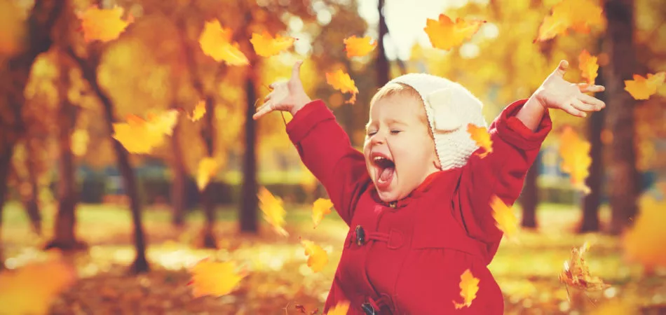 happy little child, baby girl laughing and playing in the autumn on the nature walk outdoors