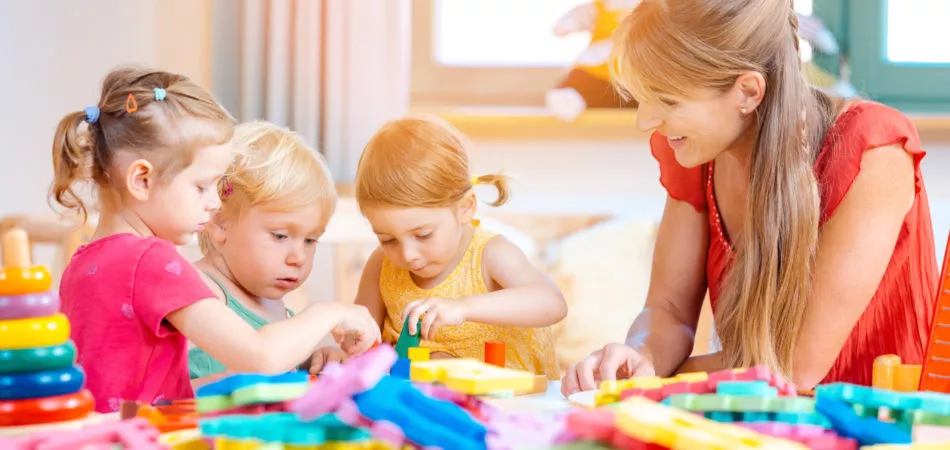 Group of children and teacher playing practical games in kindergarten